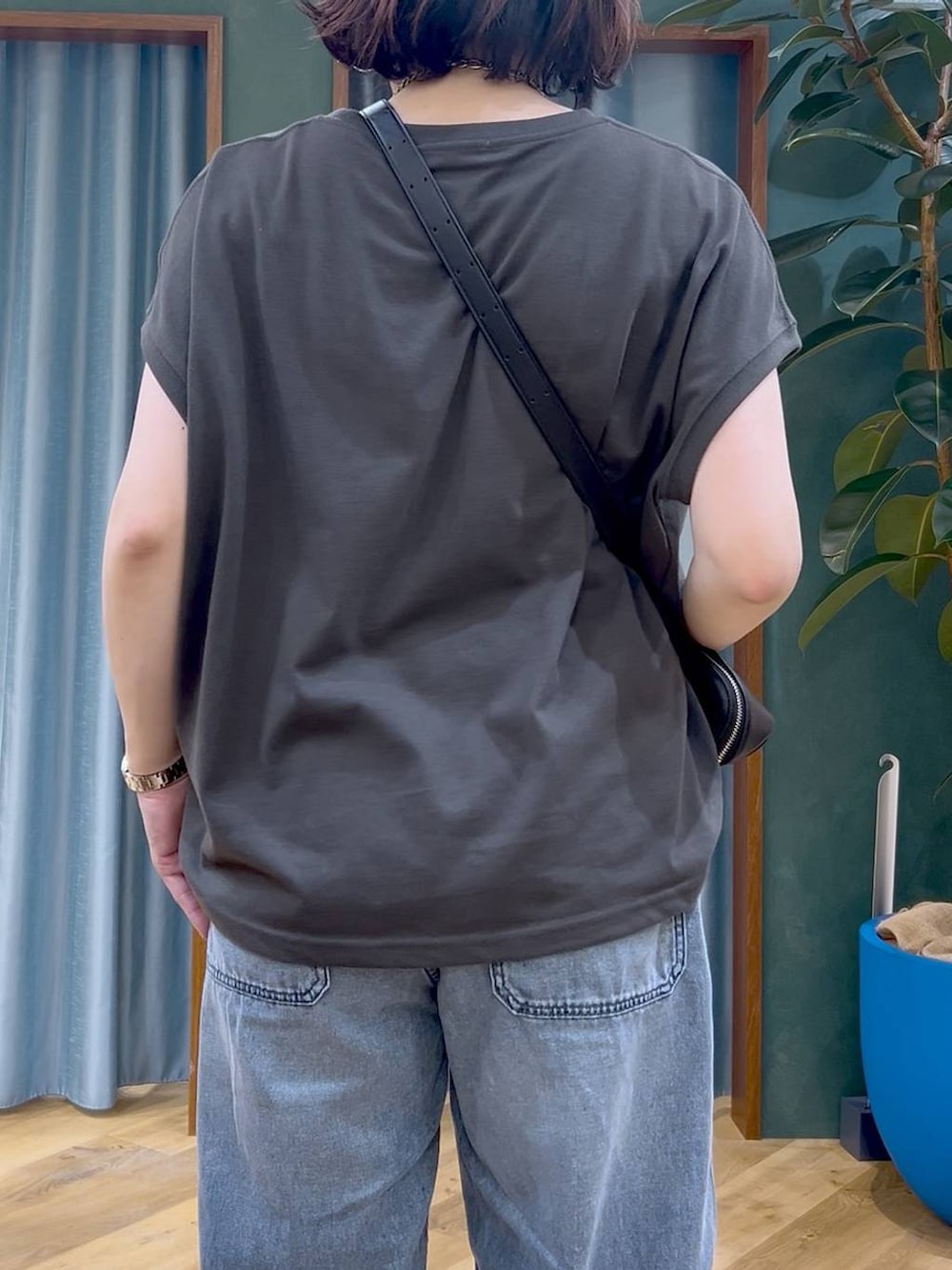 ブラック系のTシャツ/カットソー、ブルー系のデニムパンツ、ブラック系のショルダーバッグを着用したレディースの春コーディネートの7枚目の写真