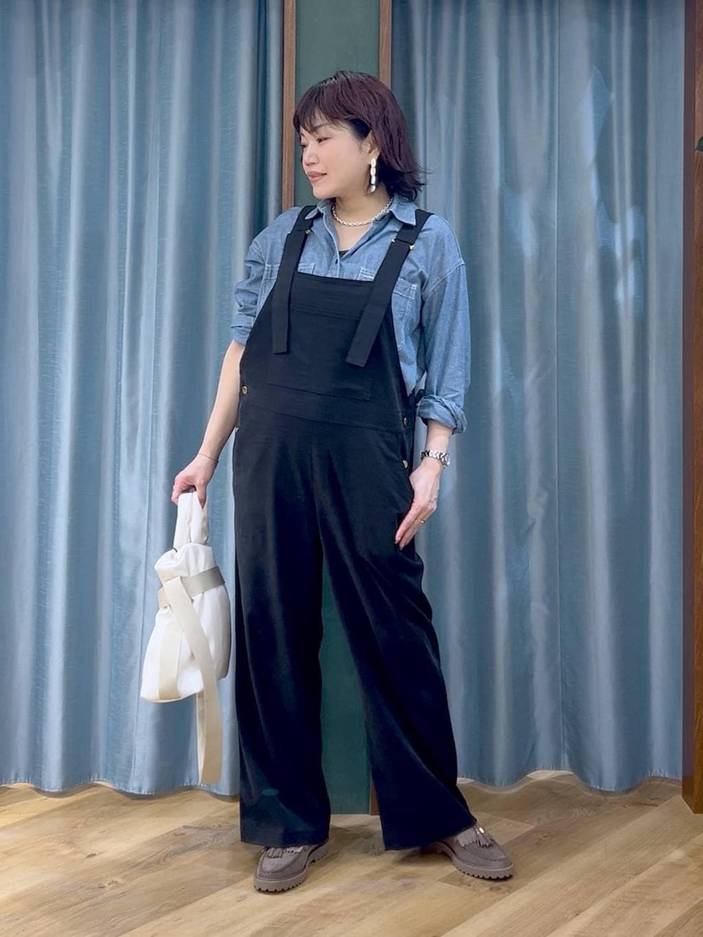 グレー系のローファー、ブラック系のサロペット/オーバーオール、ホワイト系のトートバッグを着用したレディースの春コーディネートの2枚目の写真