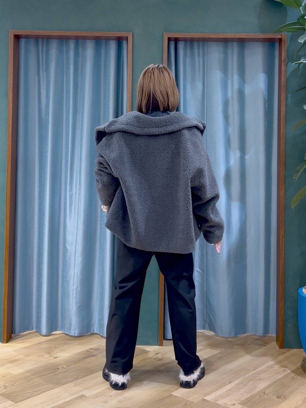 グレー系のピーコート、ブラック系のショルダーバッグ、ブラック系のスラックスを着用したレディースの秋コーディネートの4枚目の写真