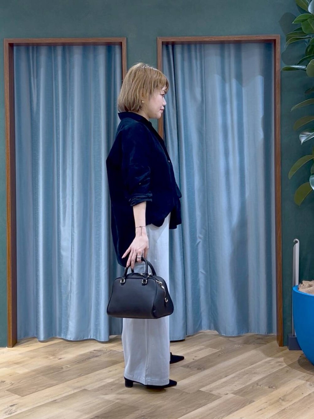 ブラック系のボストンバッグ、グレー系のその他パンツ、ブルー系のシャツ/ブラウスを着用したレディースの秋コーディネートの2枚目の写真