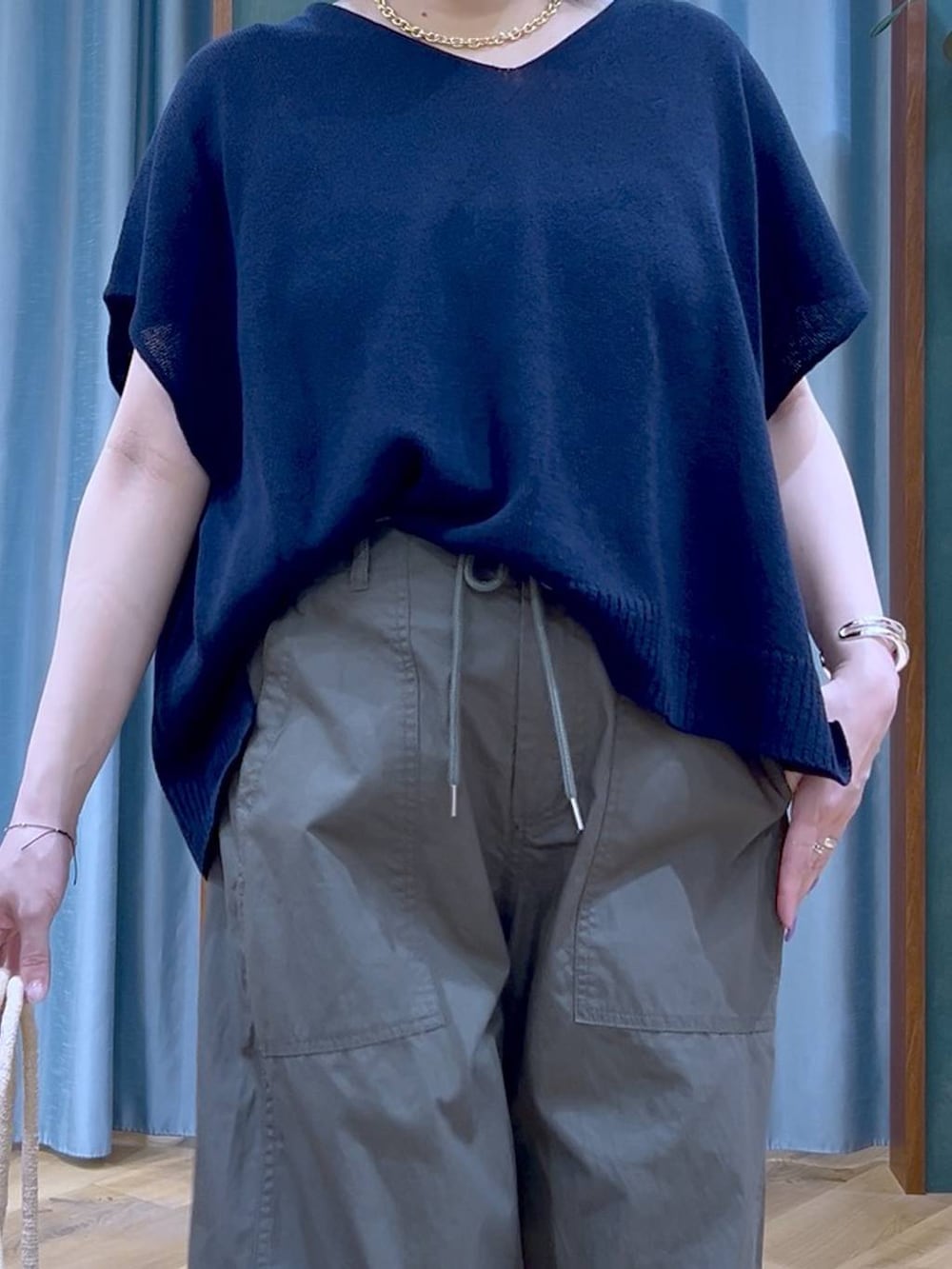 グリーン系のカーゴパンツ、ブラック系のサンダル、ベージュ系のかごバッグを着用したレディースの夏コーディネートの8枚目の写真