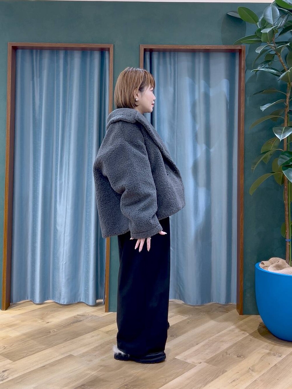 グレー系のピーコート、ブラック系のショルダーバッグ、ブラック系のスラックスを着用したレディースの秋コーディネートの3枚目の写真