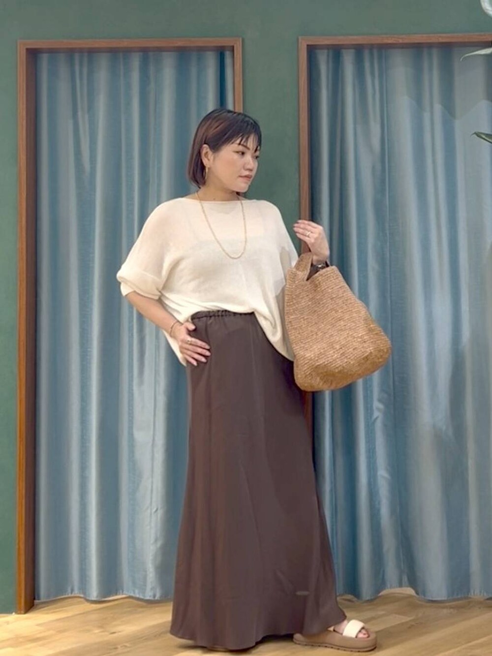 ブラウン系のかごバッグ、ホワイト系のサンダル、ホワイト系のニット/セーターを着用したレディースの夏コーディネートの2枚目の写真