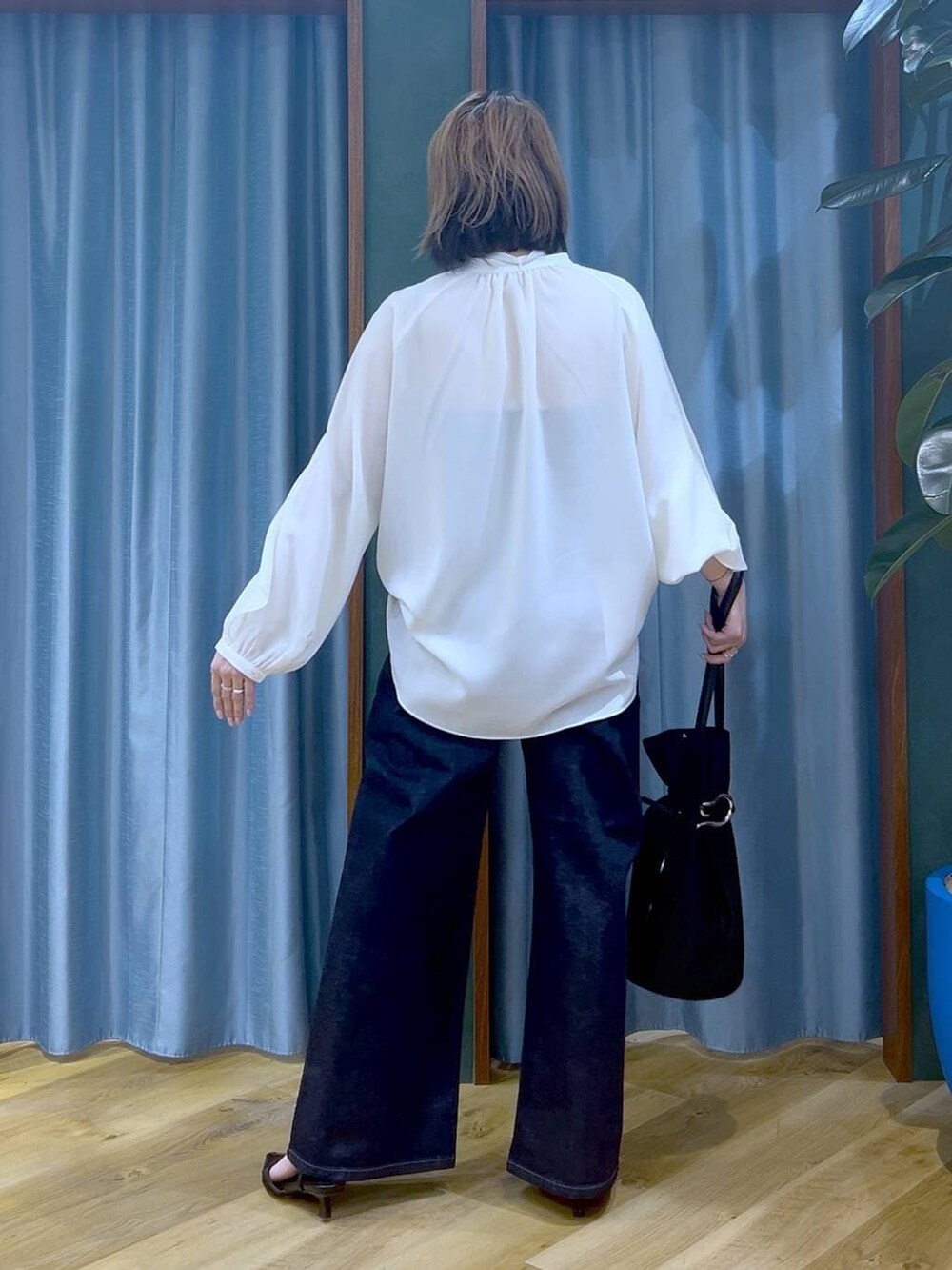 ブルー系のデニムパンツ、ホワイト系のシャツ/ブラウス、ブラック系のトートバッグを着用したレディースの冬コーディネートの6枚目の写真