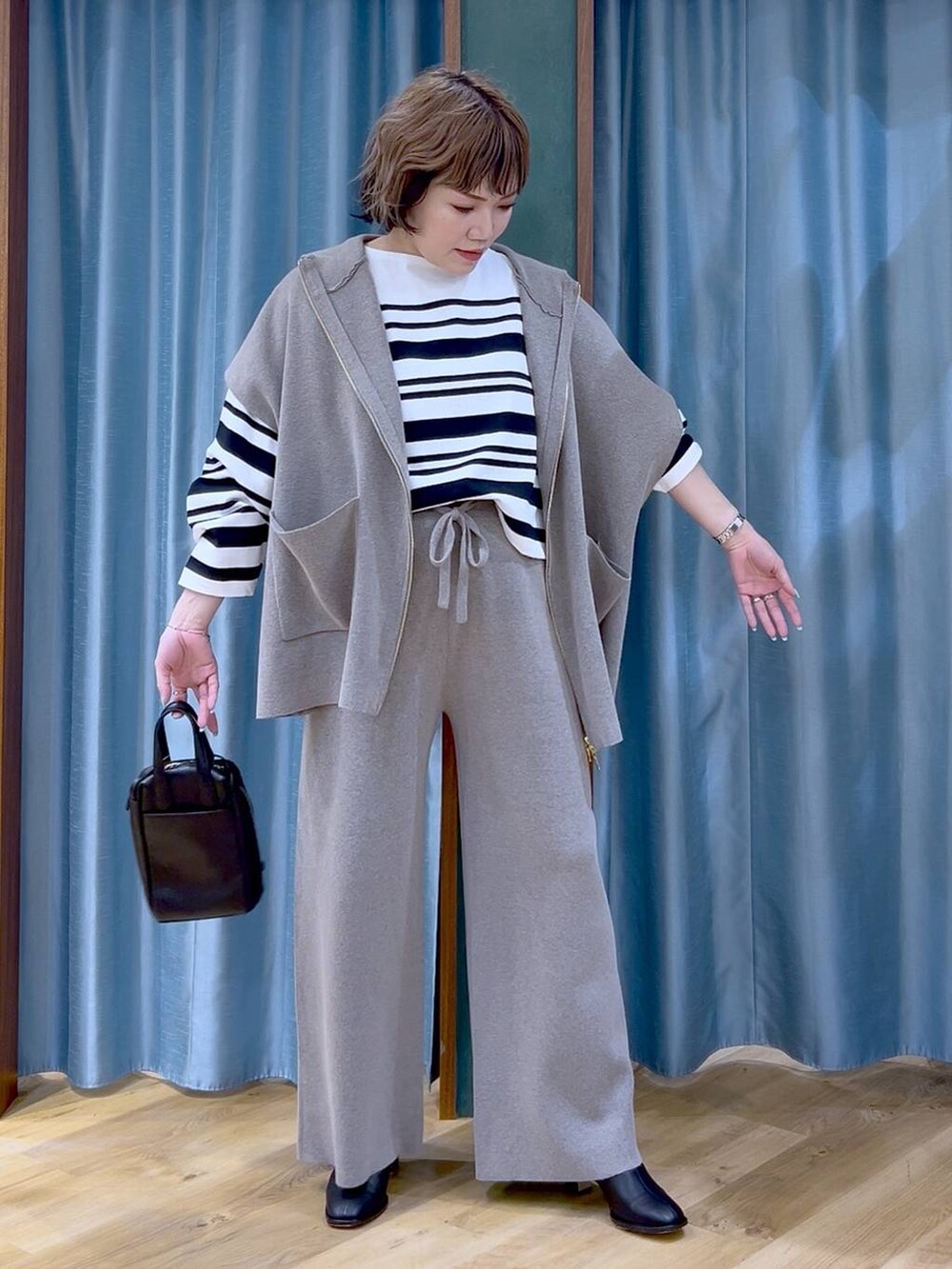 グレー系のベスト、グレー系のその他パンツ、ブラック系のブーツを着用したレディースの冬コーディネートの2枚目の写真