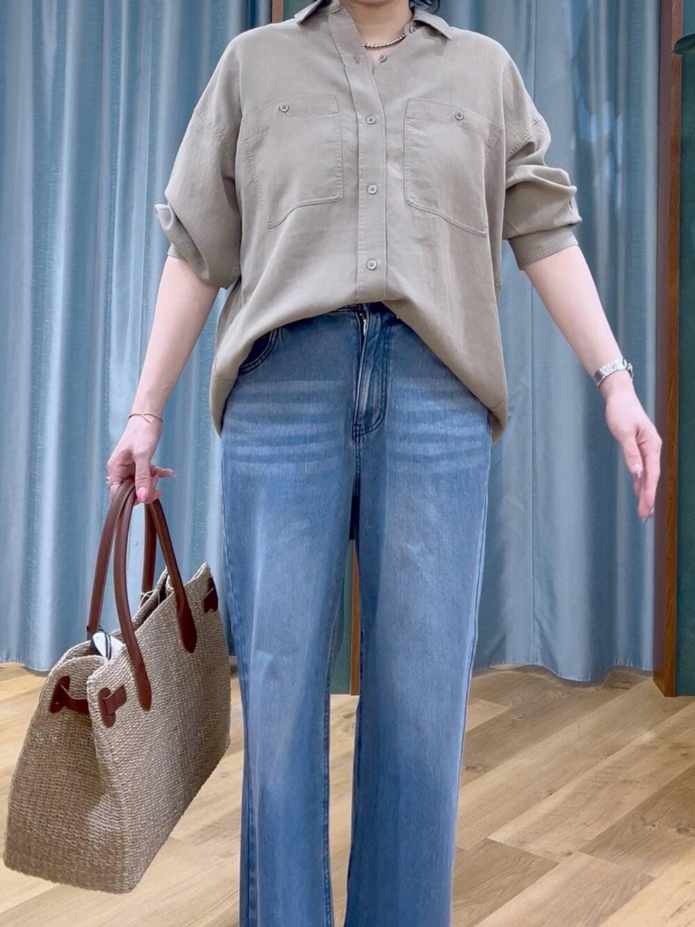 ブルー系のデニムパンツ、グリーン系のシャツ/ブラウス、ベージュ系のかごバッグを着用したレディースの春コーディネートの6枚目の写真