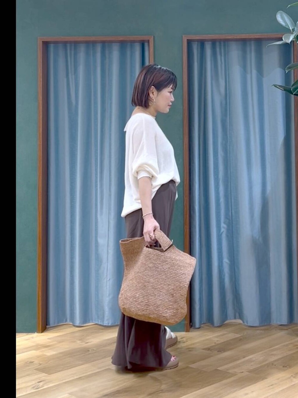ブラウン系のかごバッグ、ホワイト系のサンダル、ホワイト系のニット/セーターを着用したレディースの夏コーディネートの3枚目の写真