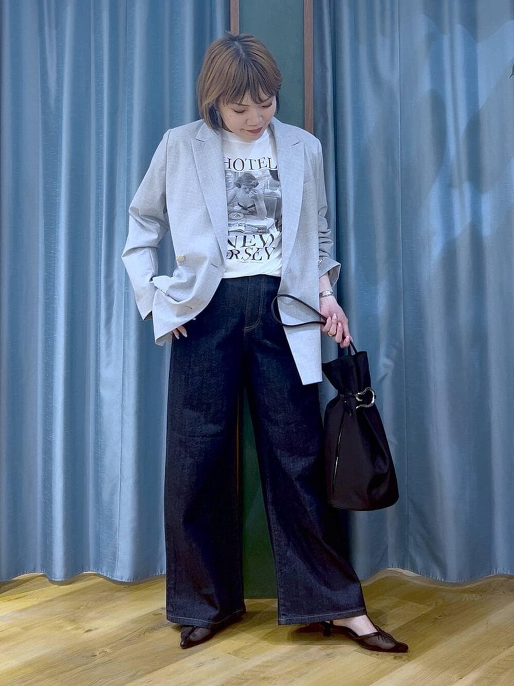 ブルー系のデニムパンツ、グレー系のテーラードジャケット、ホワイト系のTシャツ/カットソーを着用したレディースの冬コーディネートの4枚目の写真