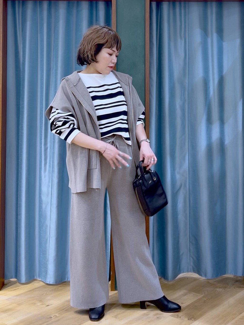 グレー系のベスト、グレー系のその他パンツ、ブラック系のブーツを着用したレディースの冬コーディネートの3枚目の写真