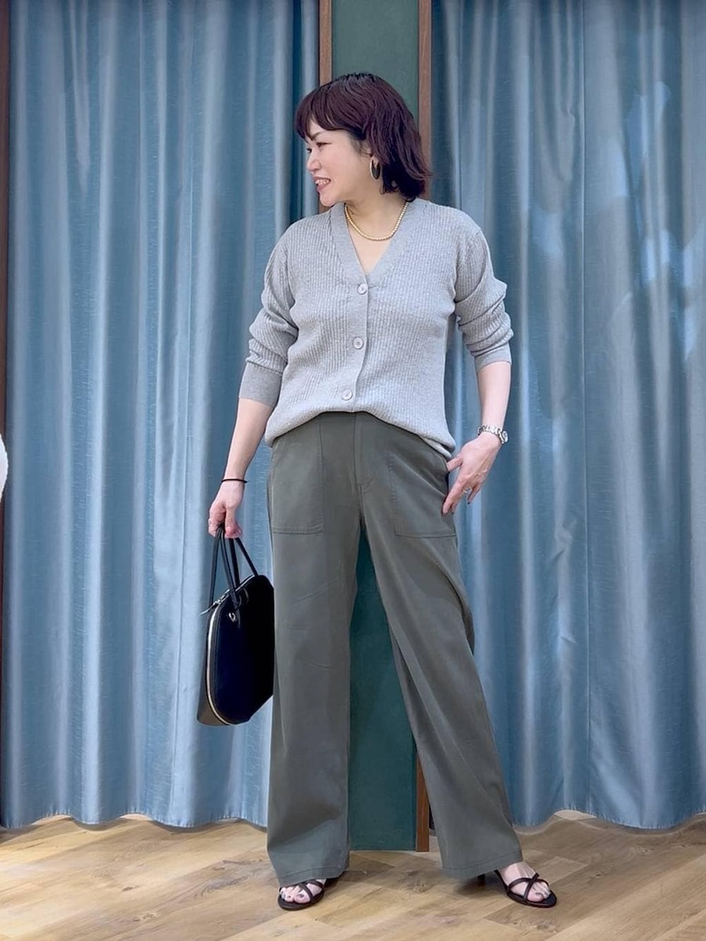 その他のトートバッグ、グレー系のカーディガン/ボレロ、グリーン系のその他パンツを着用したレディースの春コーディネートの2枚目の写真