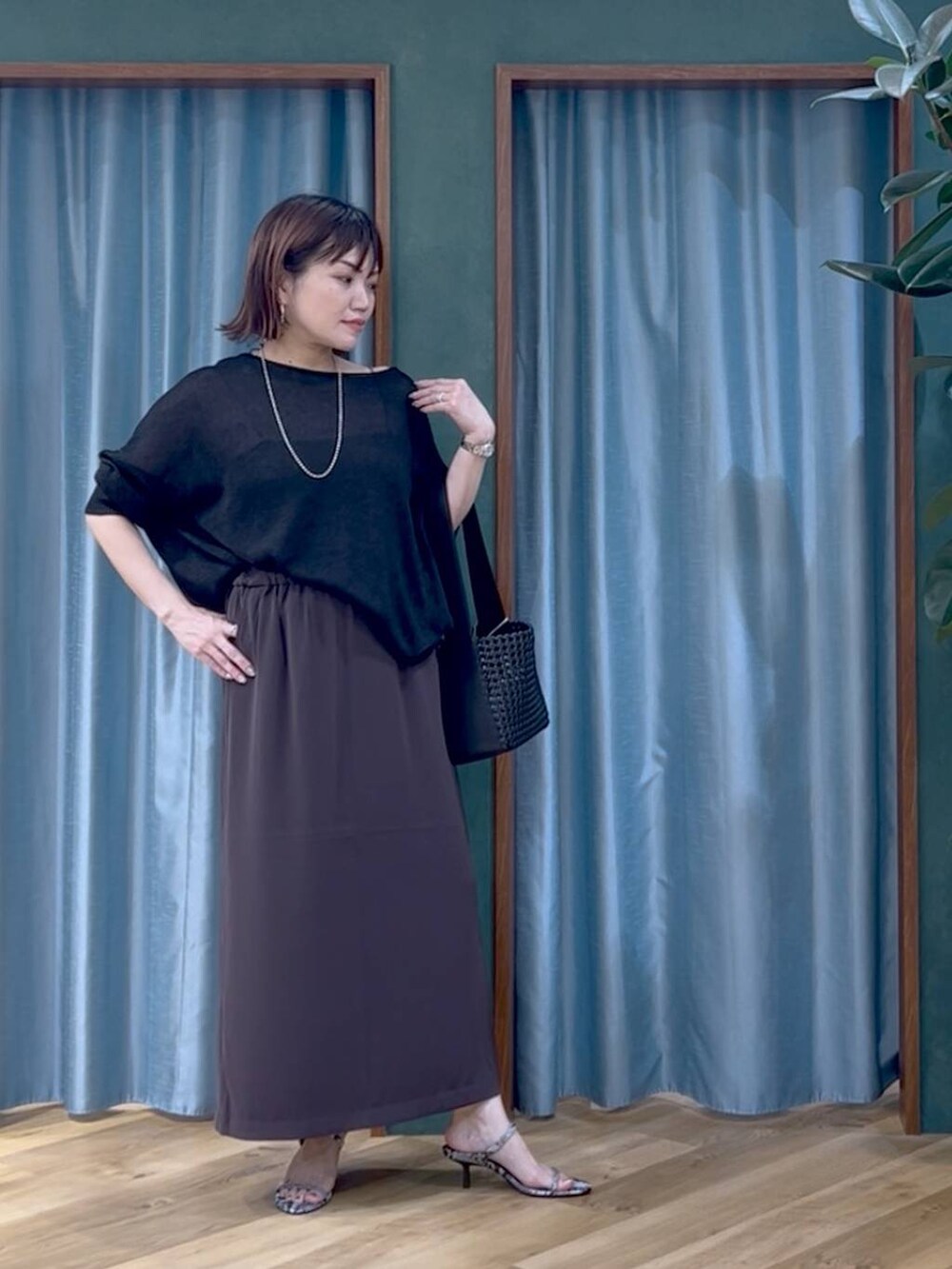 その他のサンダル、ブラック系のハンドバッグ、ブラック系のニット/セーターを着用したレディースの夏コーディネートの2枚目の写真