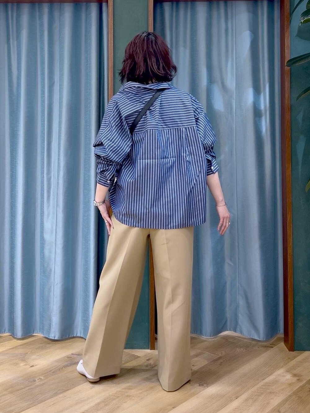 ブルー系のシャツ/ブラウス、ブラック系のショルダーバッグ、ホワイト系のパンプスを着用したレディースの春コーディネートの4枚目の写真