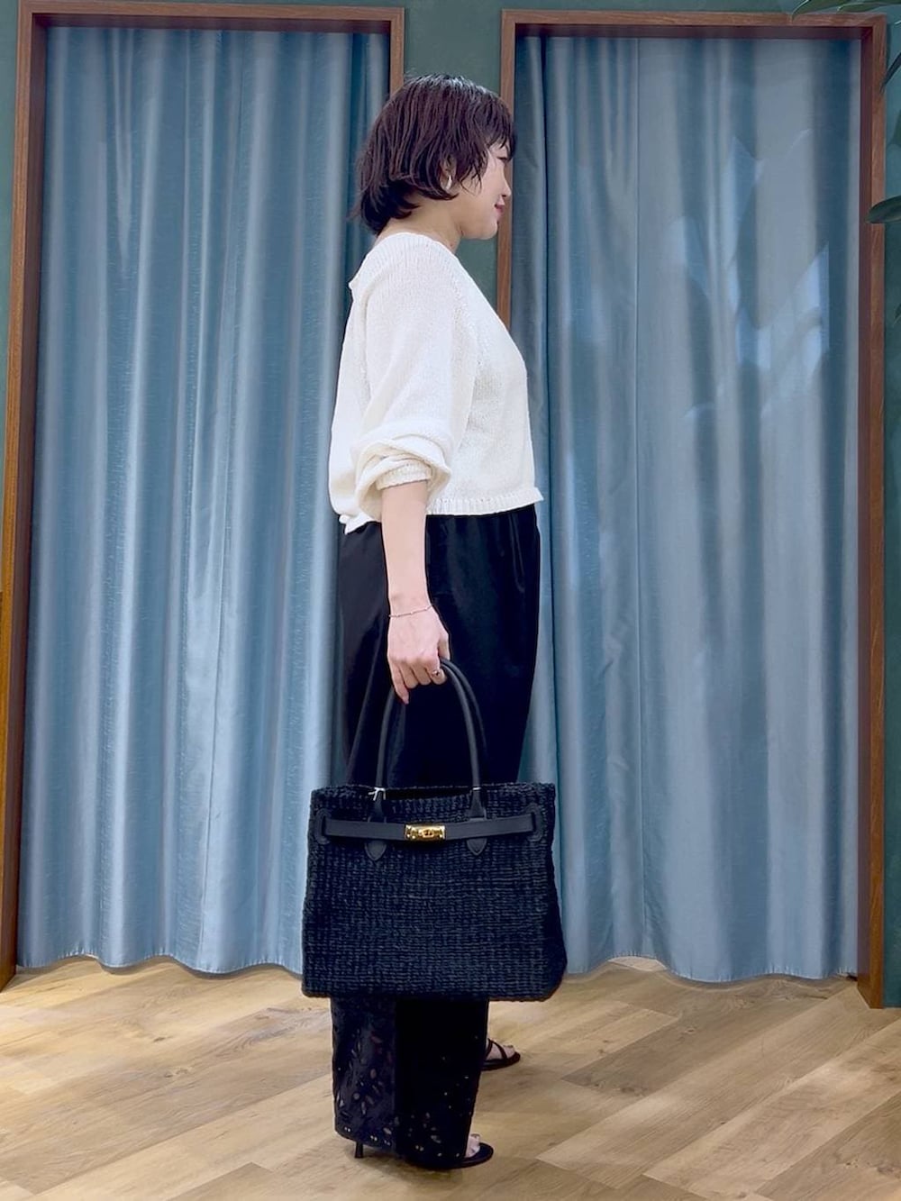 ホワイト系のニット/セーター、ブラック系のその他パンツ、ブラック系のサンダルを着用したレディースの春コーディネートの4枚目の写真