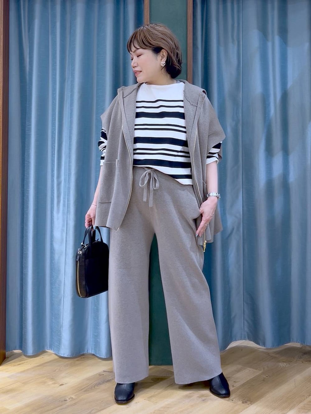 グレー系のベスト、グレー系のその他パンツ、ブラック系のブーツを着用したレディースの冬コーディネートの4枚目の写真