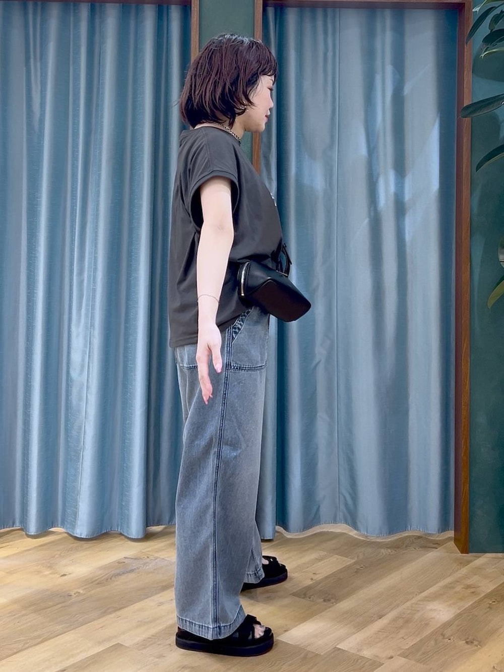 ブラック系のTシャツ/カットソー、ブルー系のデニムパンツ、ブラック系のショルダーバッグを着用したレディースの春コーディネートの4枚目の写真