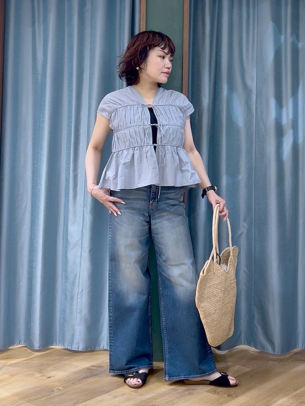 ブルー系のデニムパンツ、ブルー系のシャツ/ブラウス、ブラック系のサンダルを着用したレディースの春コーディネートの2枚目の写真