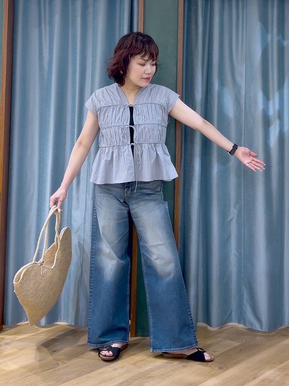 ブルー系のデニムパンツ、ブルー系のシャツ/ブラウス、ブラック系のサンダルを着用したレディースの春コーディネートの3枚目の写真