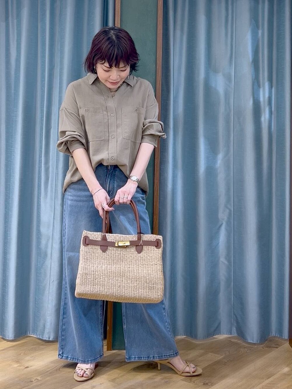 ブルー系のデニムパンツ、グリーン系のシャツ/ブラウス、ベージュ系のかごバッグを着用したレディースの春コーディネートの5枚目の写真