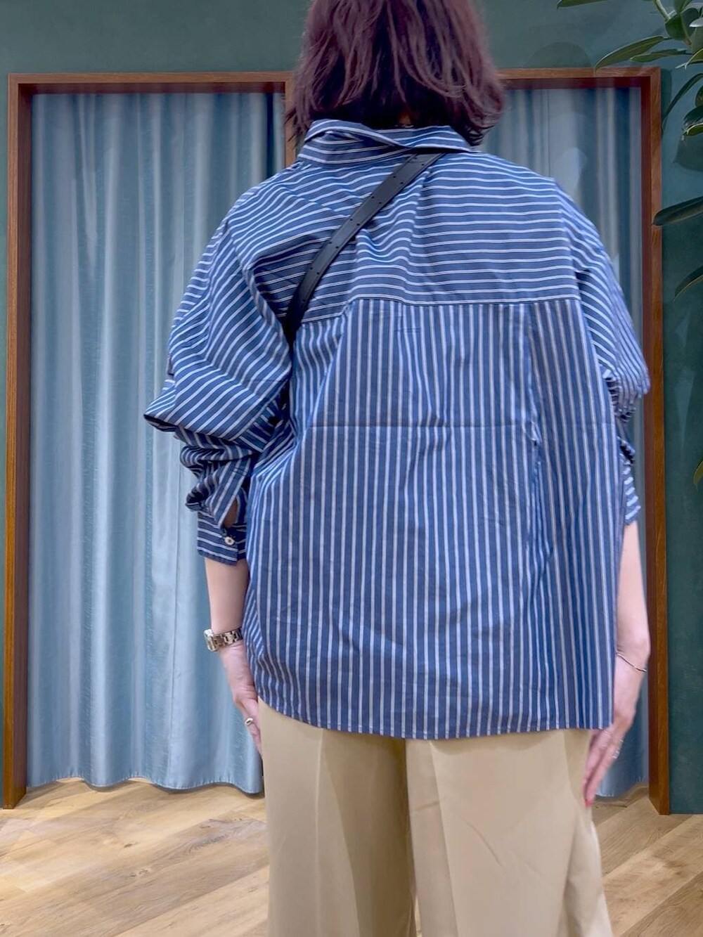 ブルー系のシャツ/ブラウス、ブラック系のショルダーバッグ、ホワイト系のパンプスを着用したレディースの春コーディネートの6枚目の写真