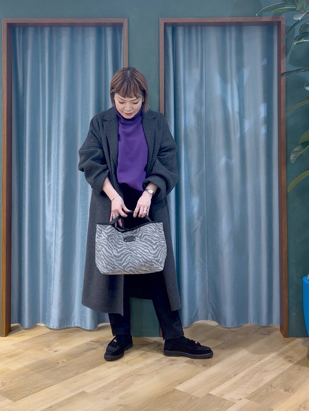 ブラック系のその他パンツ、パープル系のニット/セーター、グレー系のチェスターコートを着用したレディースの秋コーディネートの3枚目の写真