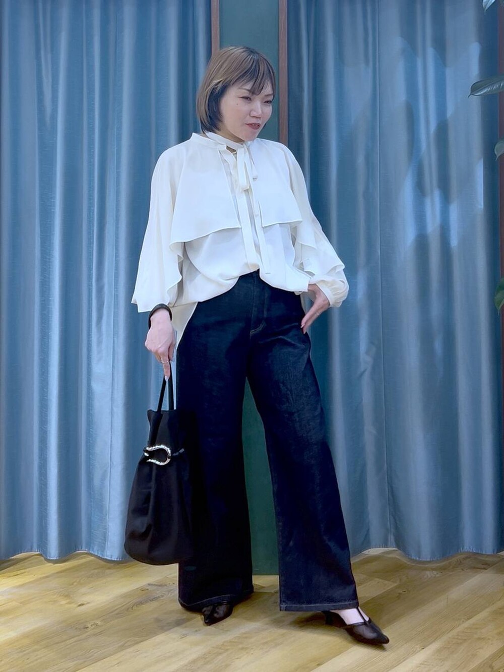 ブルー系のデニムパンツ、ホワイト系のシャツ/ブラウス、ブラック系のトートバッグを着用したレディースの冬コーディネートの5枚目の写真