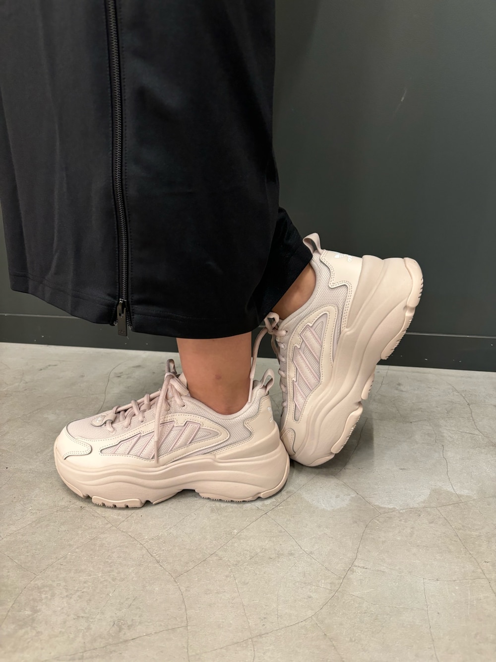 ホワイト系のポロシャツ、ブラック系のスカート、ベージュ系のスニーカーを着用したレディースの秋コーディネートの2枚目の写真