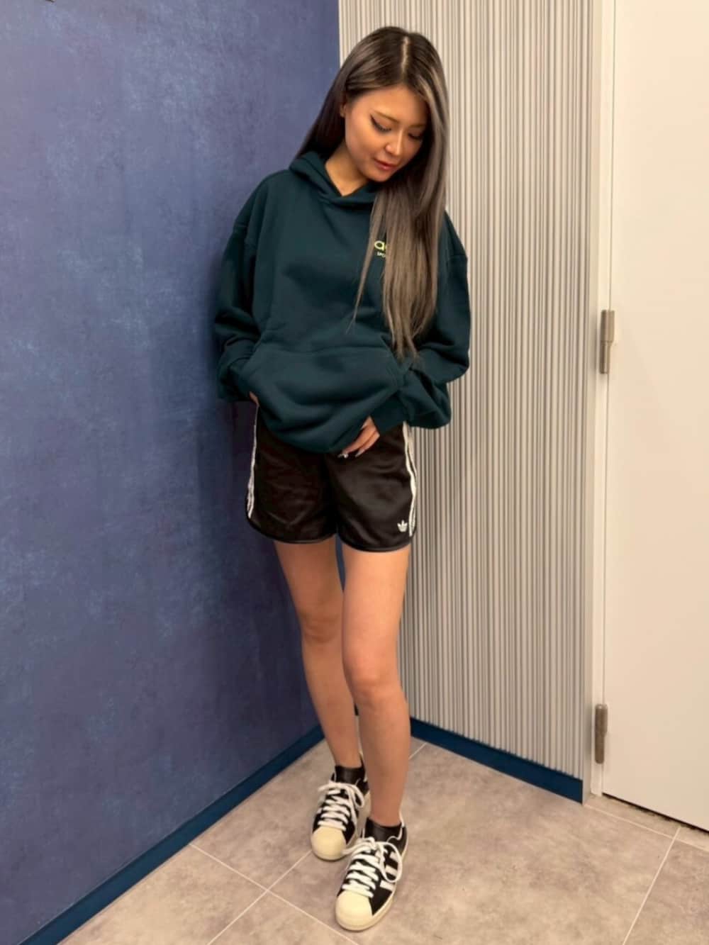 グリーン系のトップス、ブラック系のパンツ、ブラック系のシューズを着用したレディースの夏コーディネートの2枚目の写真