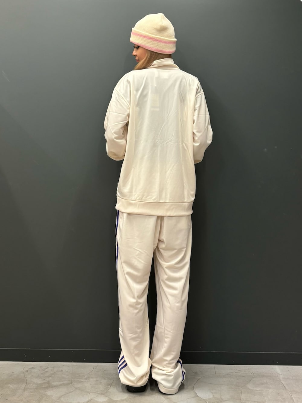 ホワイト系のジャージ、ホワイト系のスウェットパンツ、ブラック系のサンダルを着用したレディースの秋コーディネートの2枚目の写真