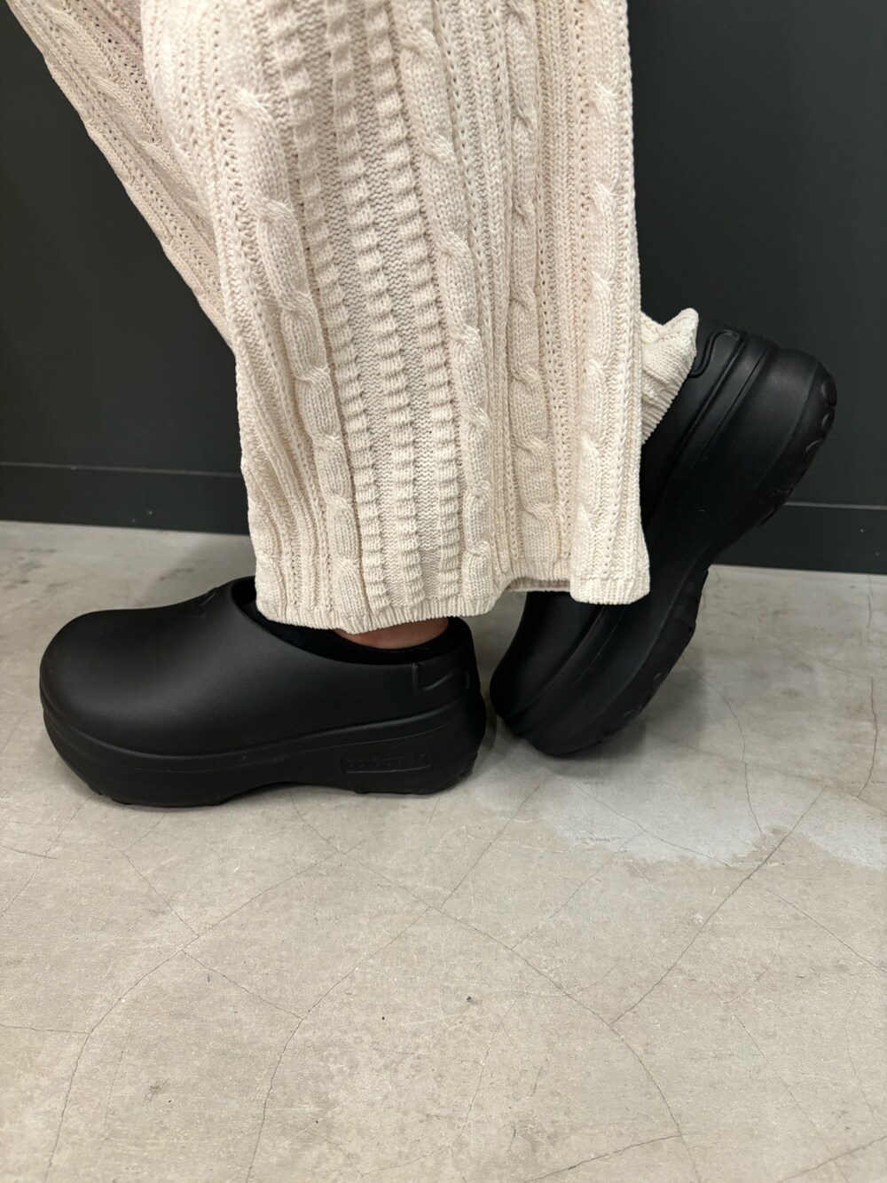 ホワイト系のその他パンツ、ブラック系のサンダル、ブラック系のポロシャツを着用したレディースの秋コーディネートの3枚目の写真