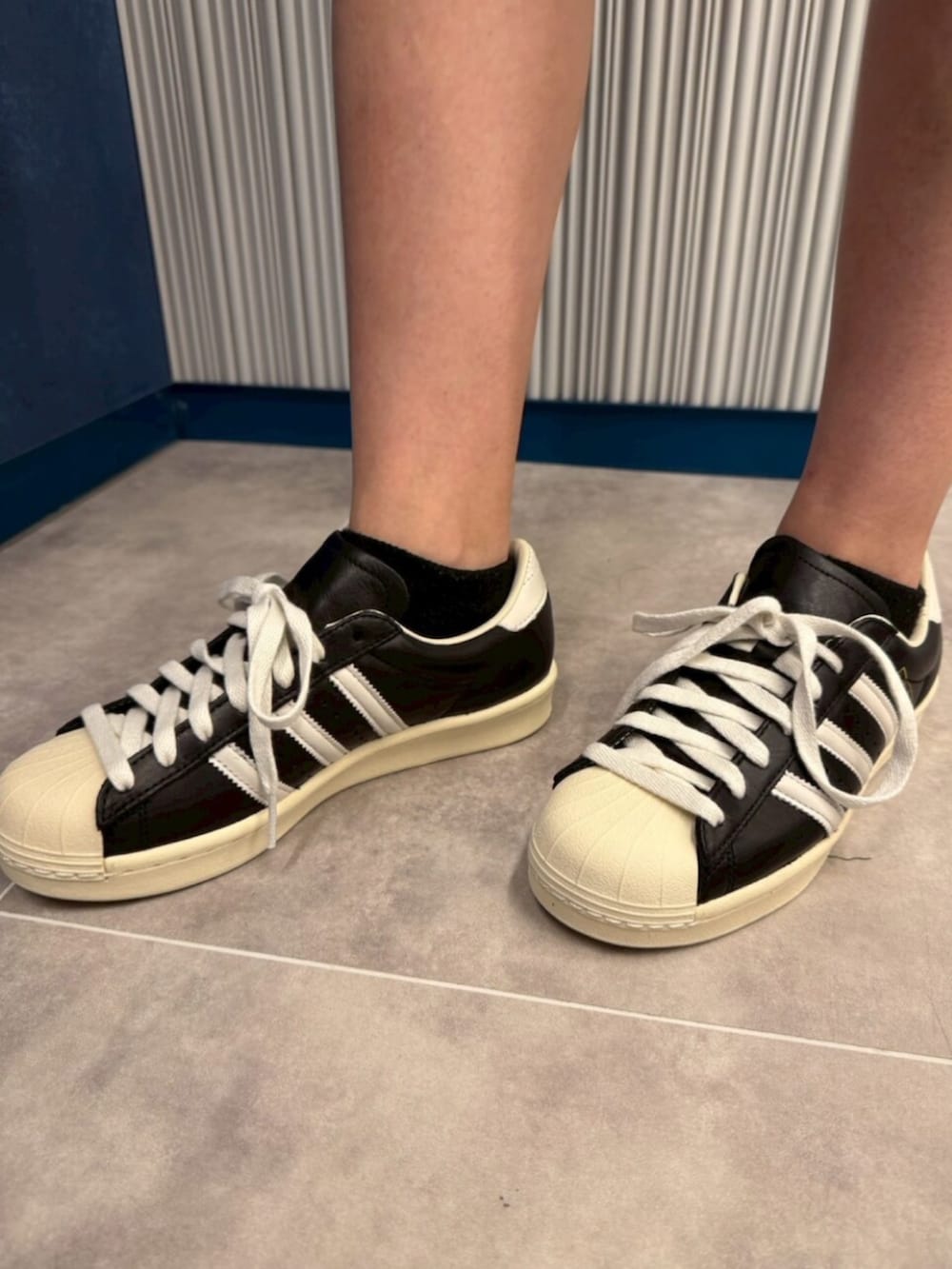 グリーン系のトップス、ブラック系のパンツ、ブラック系のシューズを着用したレディースの夏コーディネートの4枚目の写真