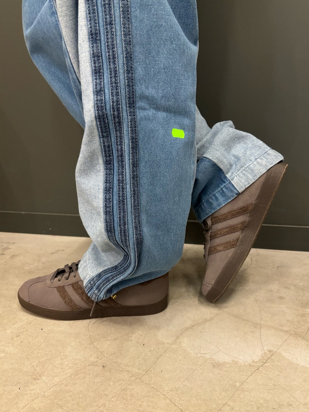 グレー系のスウェット、ブルー系のデニムパンツ、グレー系のシューズを着用したレディースの秋コーディネートの3枚目の写真