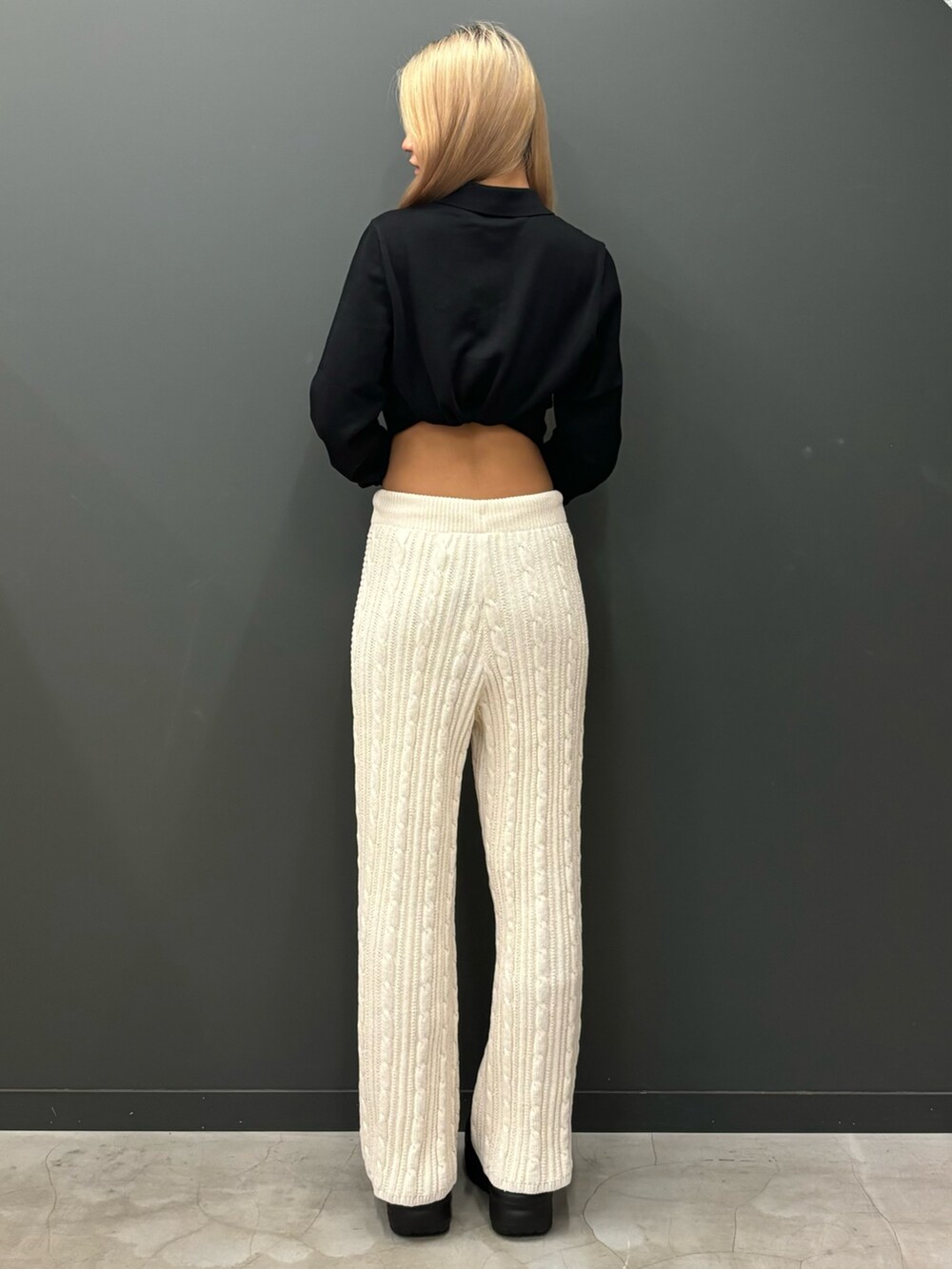 ホワイト系のその他パンツ、ブラック系のサンダル、ブラック系のポロシャツを着用したレディースの秋コーディネートの2枚目の写真