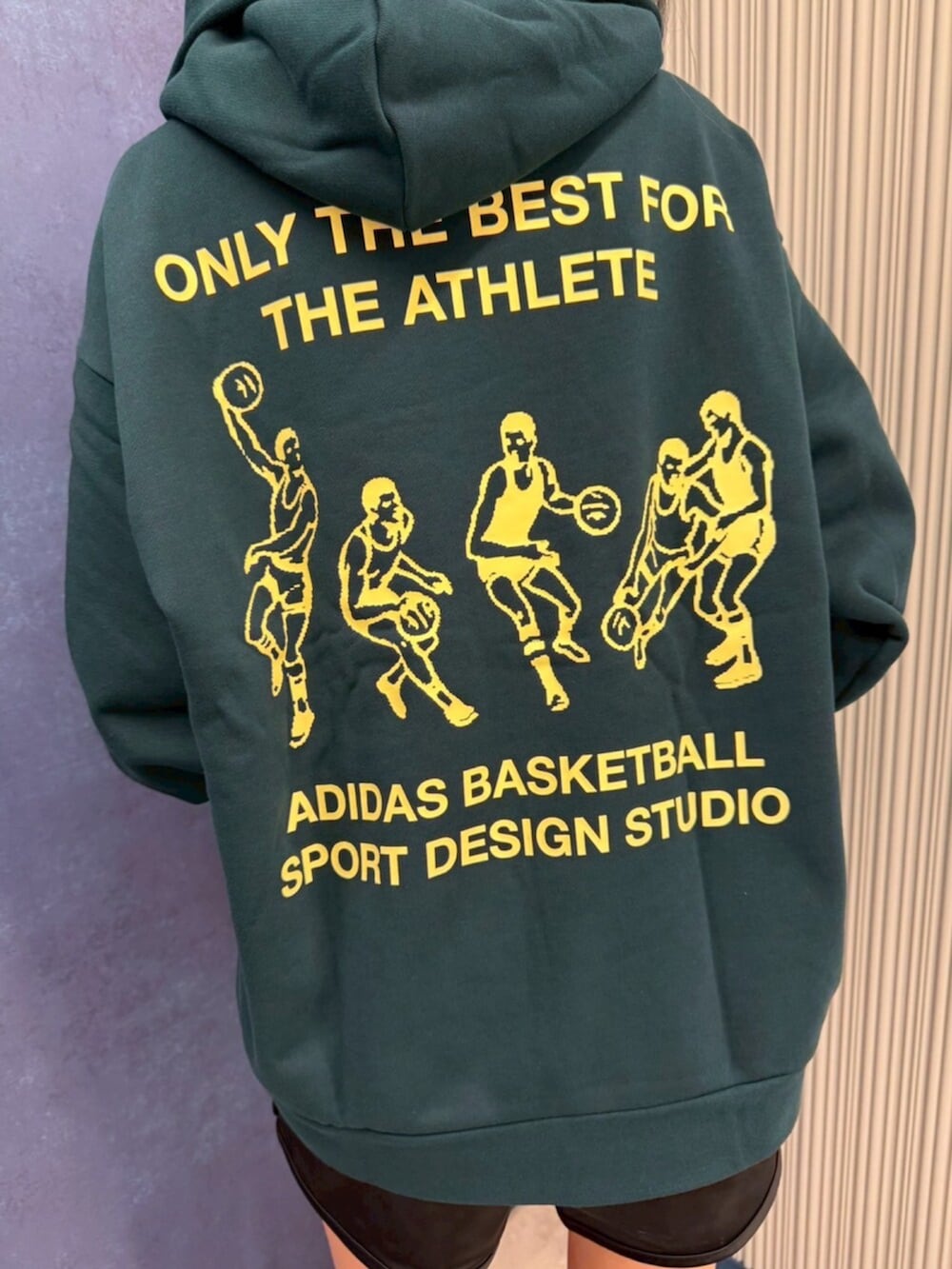 グリーン系のトップス、ブラック系のパンツ、ブラック系のシューズを着用したレディースの夏コーディネートの3枚目の写真