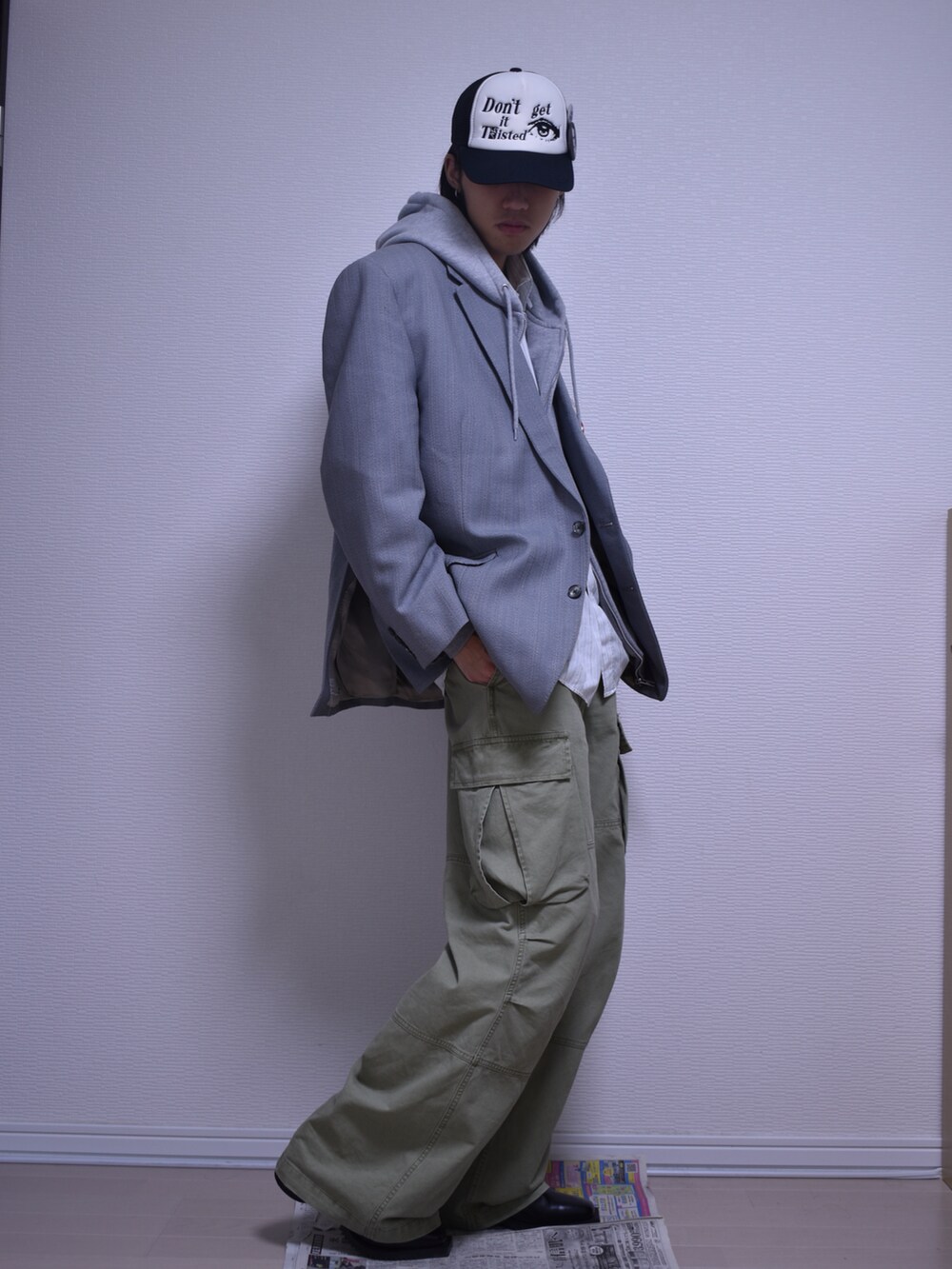 グリーン系のカーゴパンツ、グレー系のテーラードジャケット、グレー系のパーカーを着用したメンズの秋コーディネートの3枚目の写真