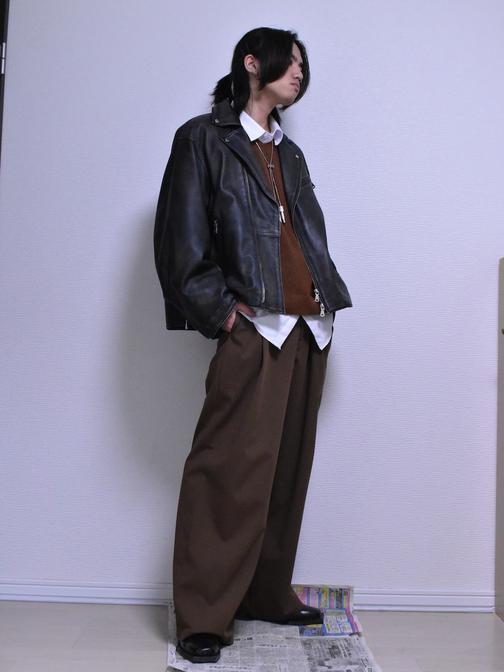 ブラウン系のスラックス、ブラック系のライダースジャケット、ブラウン系のニット/セーターを着用したメンズの冬コーディネートの3枚目の写真