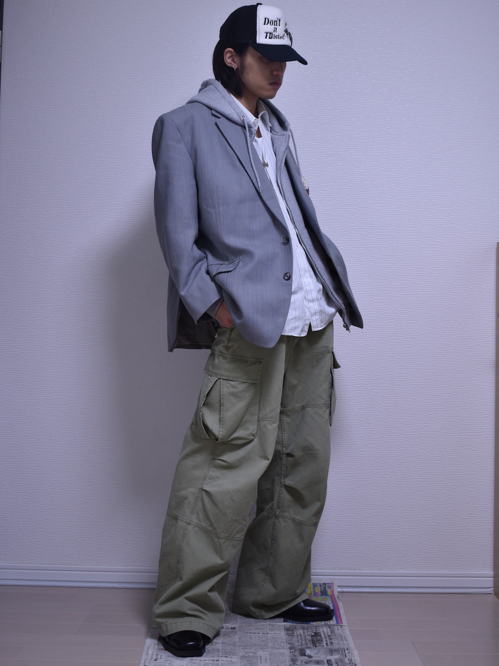 グリーン系のカーゴパンツ、グレー系のテーラードジャケット、グレー系のパーカーを着用したメンズの秋コーディネートの2枚目の写真