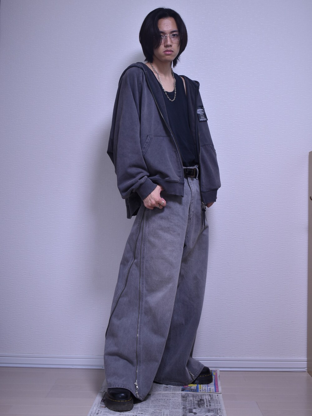 グレー系のパーカー、グレー系のデニムパンツ、ブラック系のブーツを着用したメンズの秋コーディネートの3枚目の写真