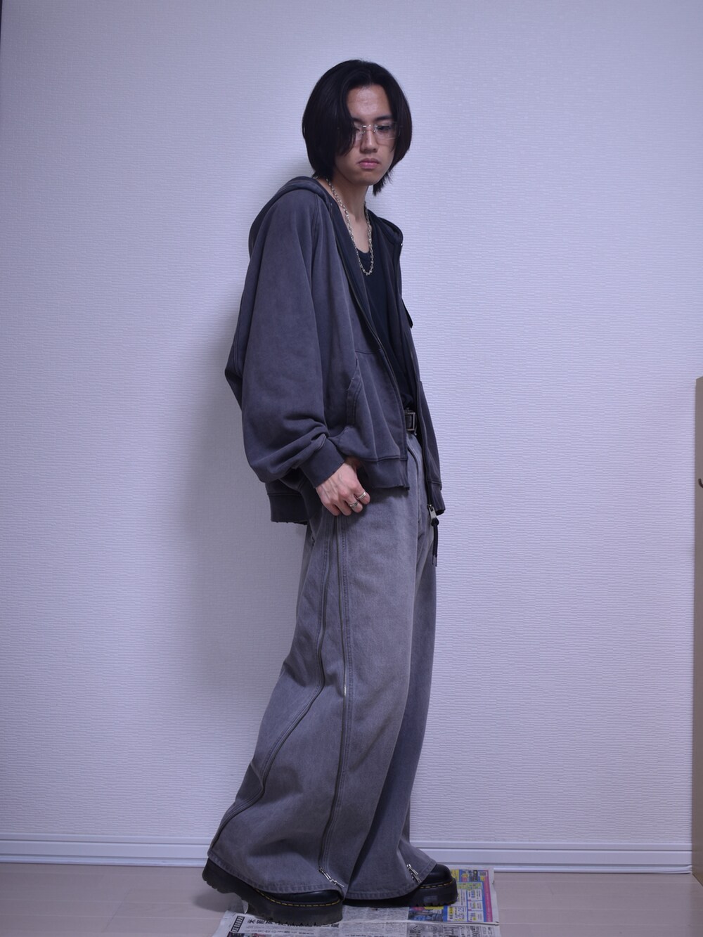 グレー系のパーカー、グレー系のデニムパンツ、ブラック系のブーツを着用したメンズの秋コーディネートの4枚目の写真