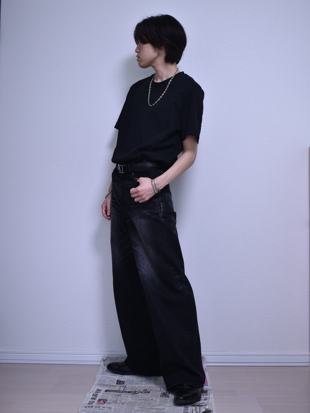 ブラック系のデニムパンツ、ブラック系のTシャツ/カットソー、ブラック系のドレスシューズを着用したメンズの夏コーディネートの5枚目の写真