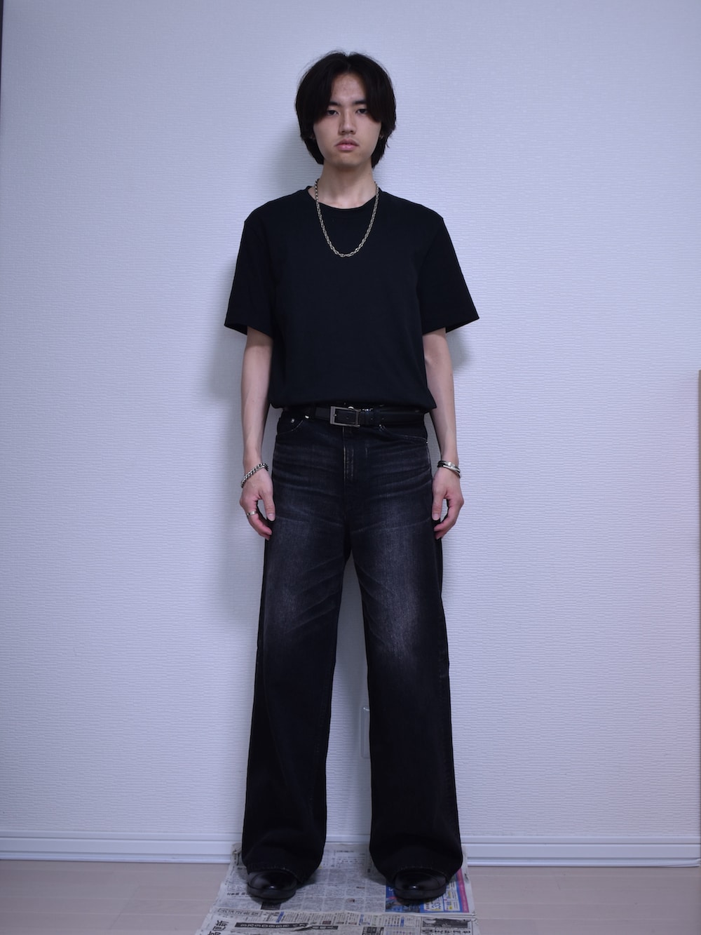 ブラック系のデニムパンツ、ブラック系のTシャツ/カットソー、ブラック系のドレスシューズを着用したメンズの夏コーディネートの3枚目の写真