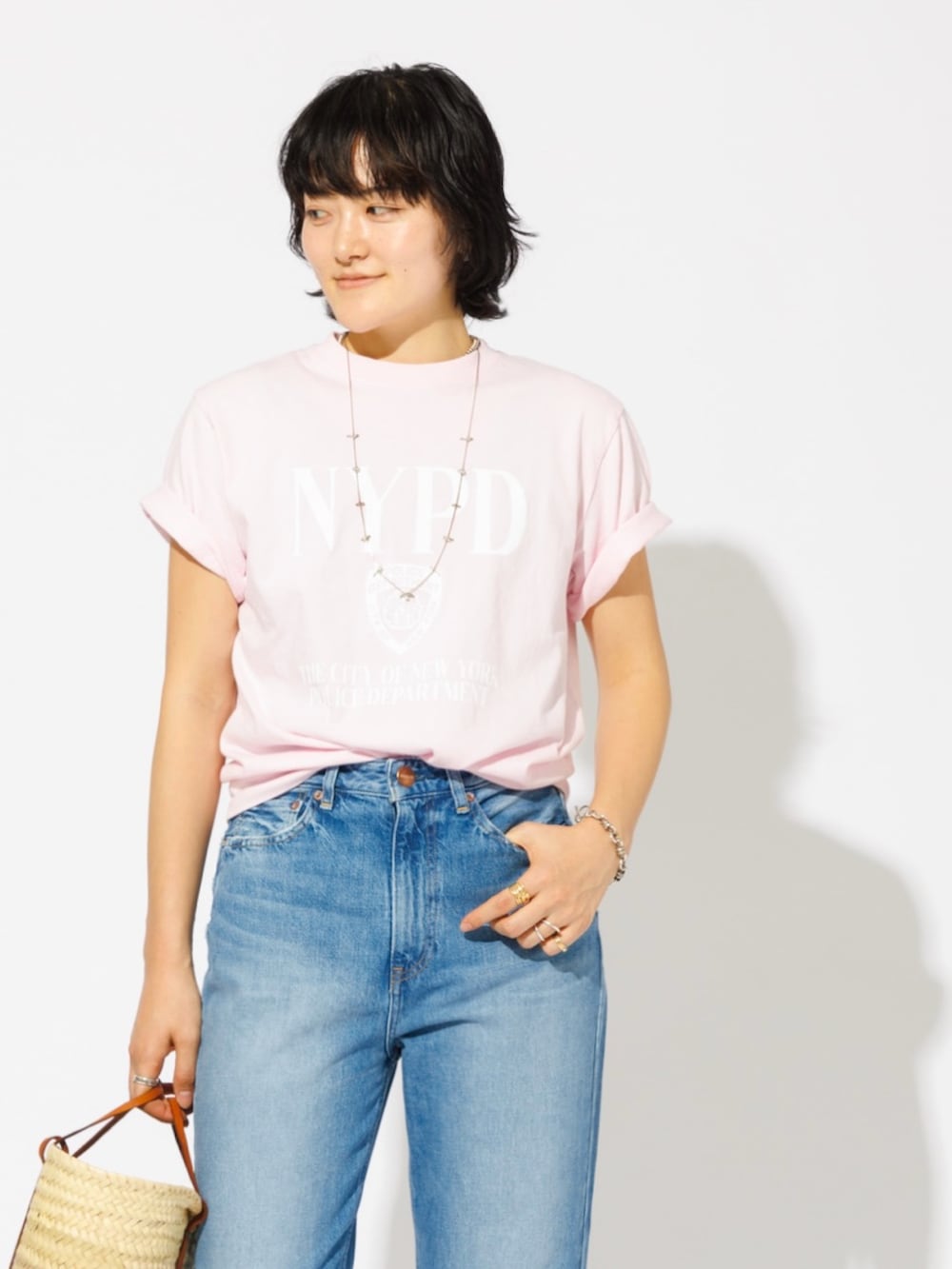 ピンク系のTシャツ/カットソー、ブルー系のデニムパンツ、ブラウン系のかごバッグを着用したレディースの春コーディネートの2枚目の写真