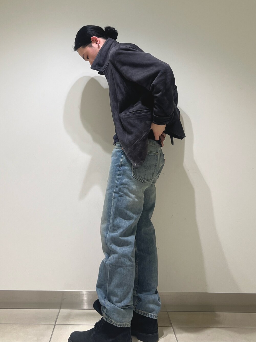 グレー系のブルゾン、ブルー系のデニムパンツを着用したメンズの冬コーディネートの2枚目の写真