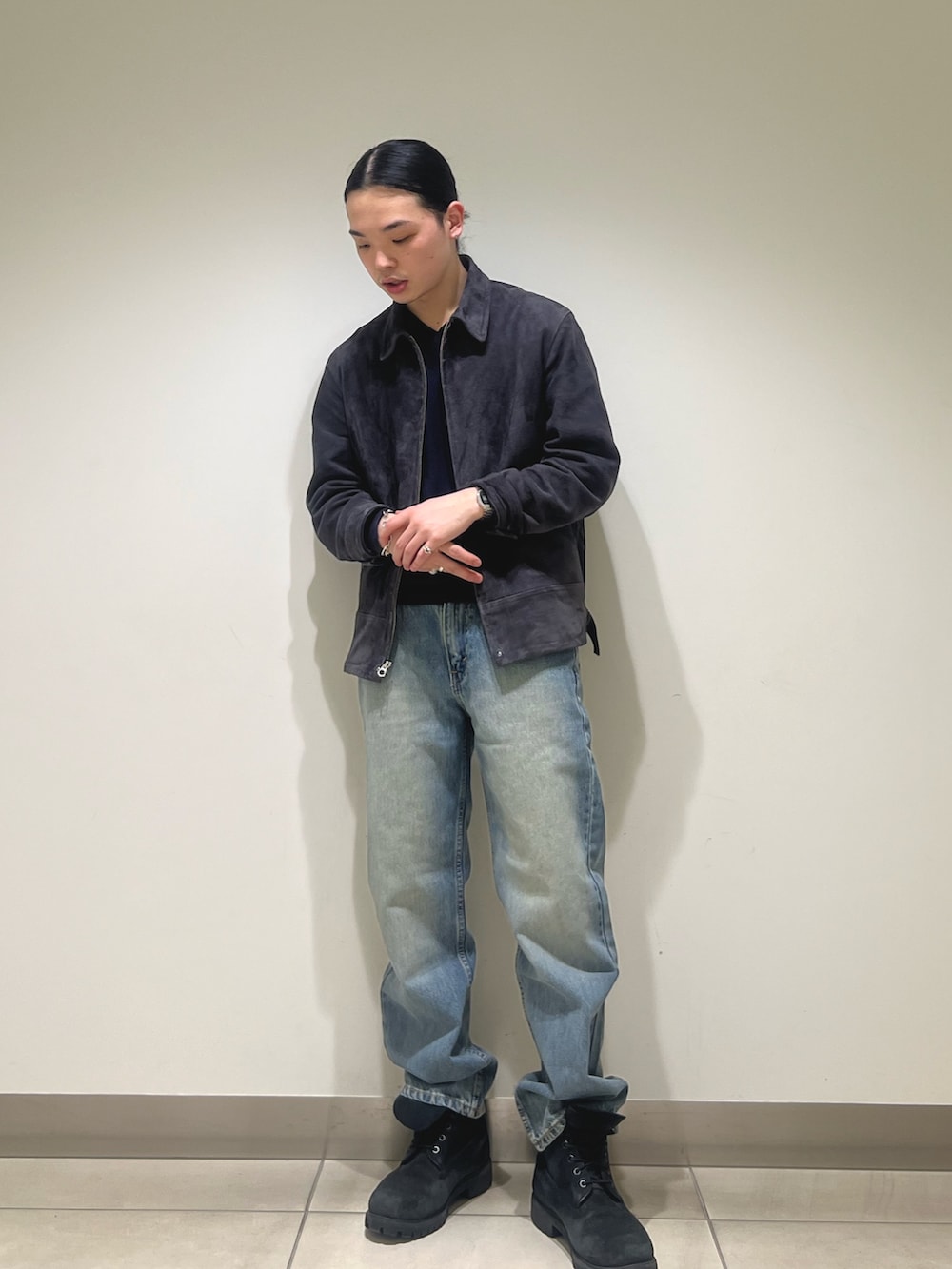 グレー系のブルゾン、ブルー系のデニムパンツを着用したメンズの冬コーディネートの4枚目の写真