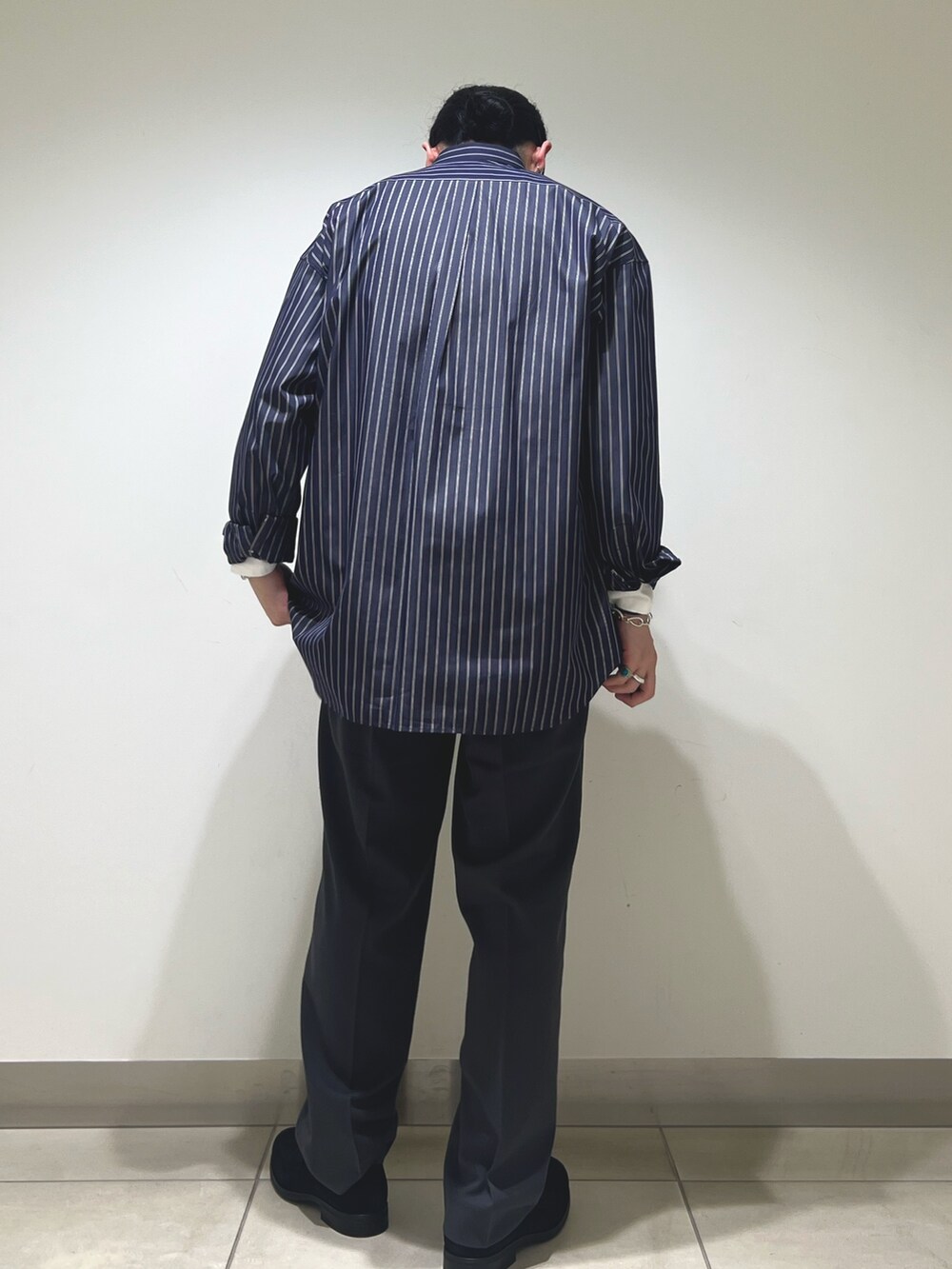 ブルー系のシャツ/ブラウス、グレー系のその他パンツ、ブラック系のドレスシューズを着用したメンズの冬コーディネートの3枚目の写真