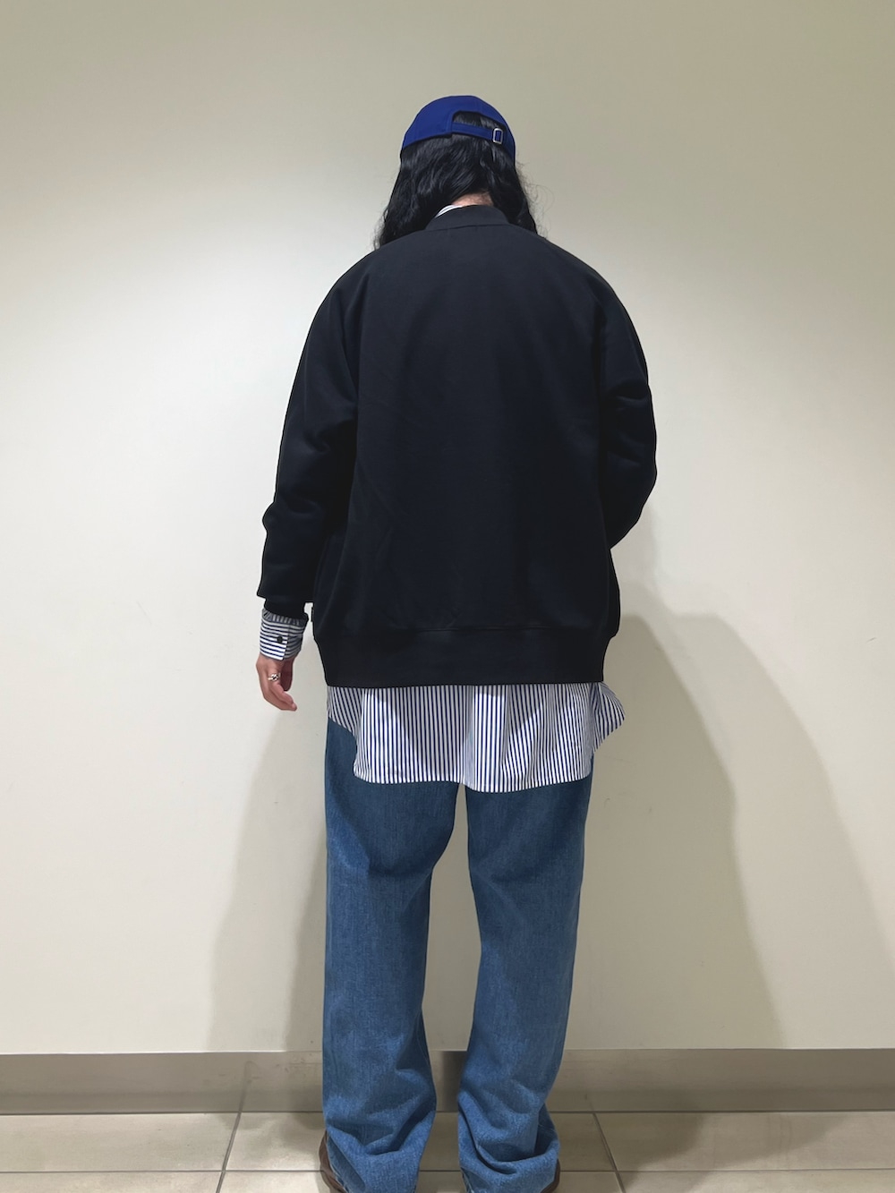 ブラック系のカーディガン/ボレロ、ブルー系のシャツ/ブラウス、ブルー系のデニムパンツを着用したメンズの冬コーディネートの3枚目の写真