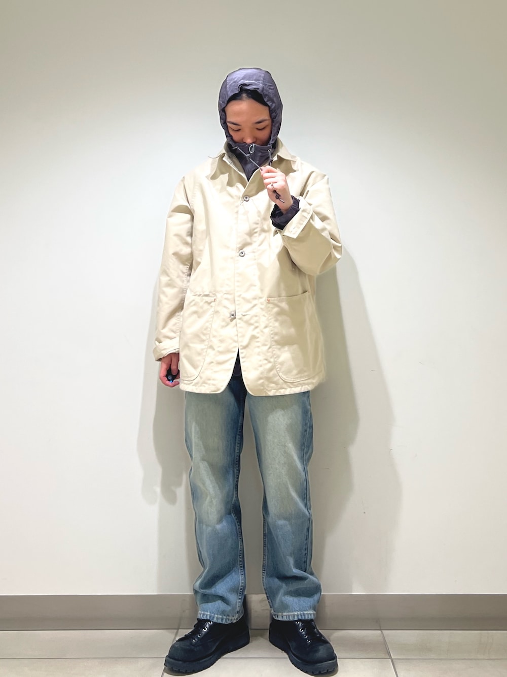 グレー系のパーカー、ホワイト系のカバーオール、ブルー系のデニムパンツを着用したメンズの冬コーディネートの7枚目の写真