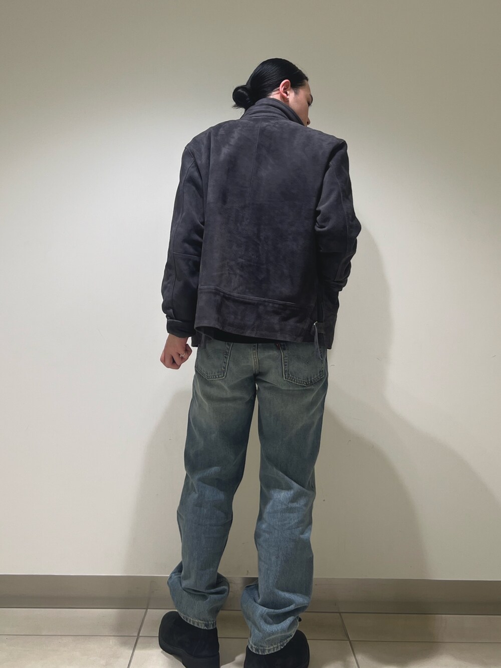 グレー系のブルゾン、ブルー系のデニムパンツを着用したメンズの冬コーディネートの3枚目の写真