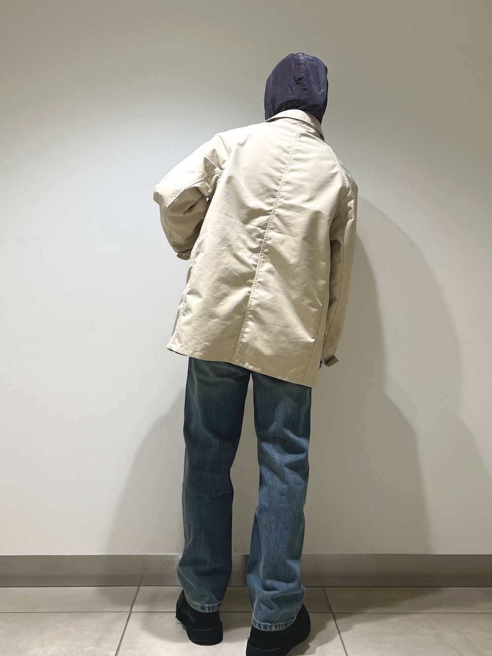 グレー系のパーカー、ホワイト系のカバーオール、ブルー系のデニムパンツを着用したメンズの冬コーディネートの6枚目の写真