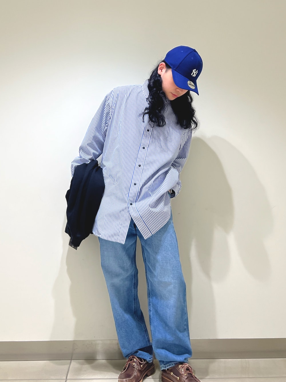 ブラック系のカーディガン/ボレロ、ブルー系のシャツ/ブラウス、ブルー系のデニムパンツを着用したメンズの冬コーディネートの5枚目の写真