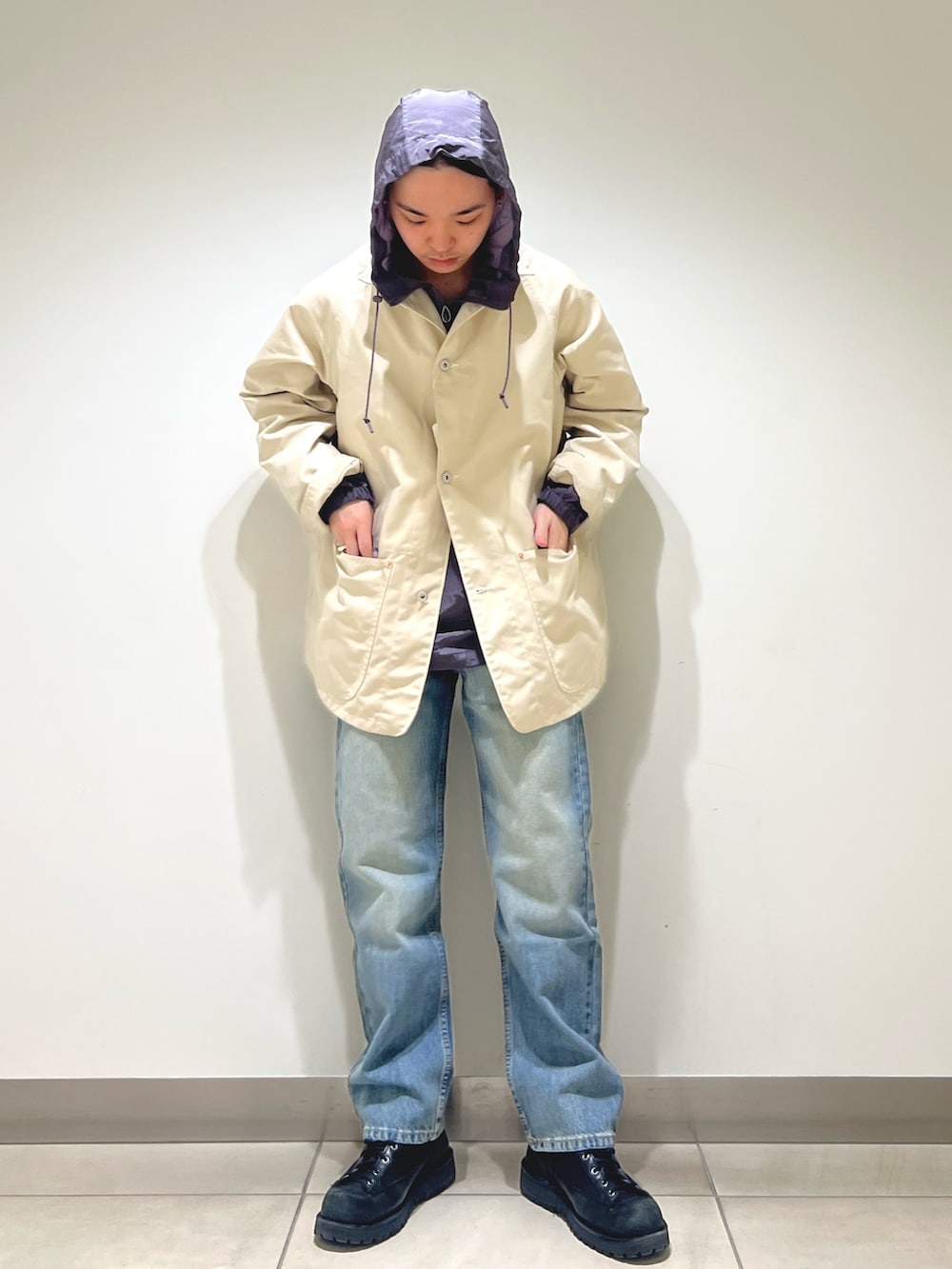 グレー系のパーカー、ホワイト系のカバーオール、ブルー系のデニムパンツを着用したメンズの冬コーディネートの4枚目の写真